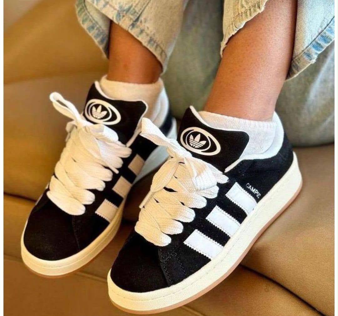 Black and white sneakers worn with light trousers