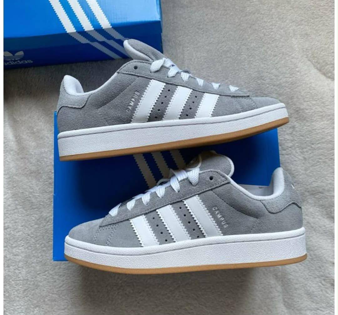 Grey sneakers displayed beside a blue box